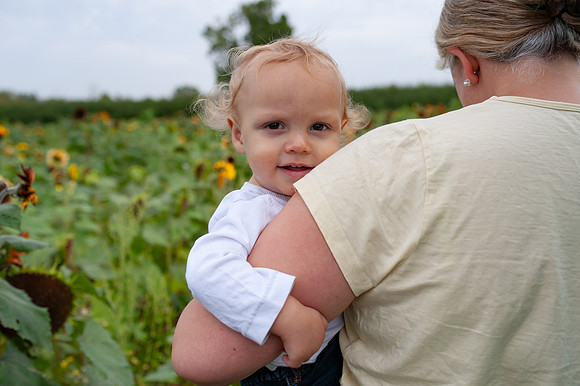 toddler-mother-sunflower-field-carrying-smiling